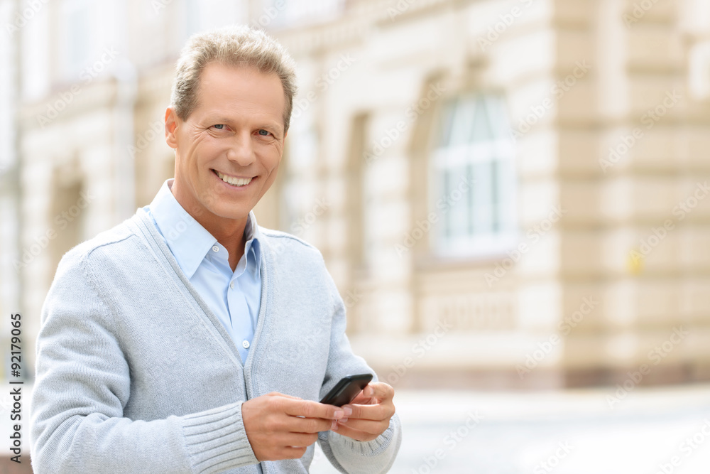Smiling man holding mobile phone Smiling man holding mobile phone