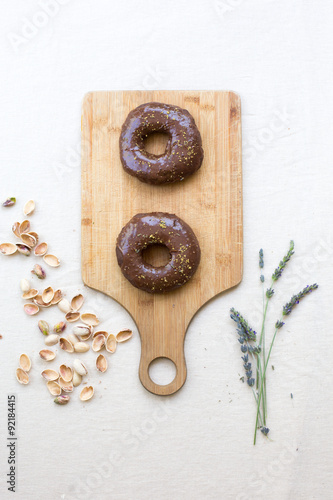 homemade donuts on a bamboo cutting board with a white linen tablecloth