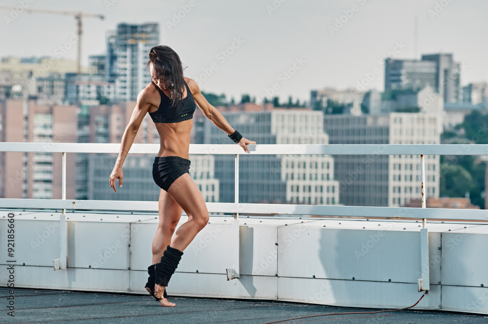 Fitness woman stretching house-top