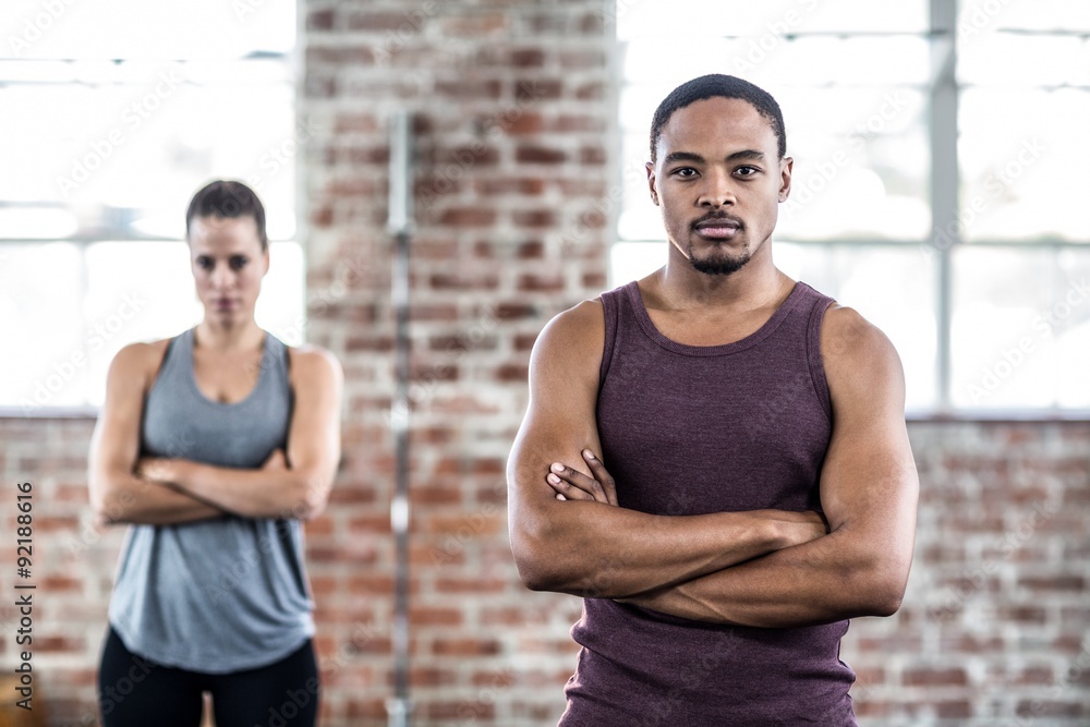 Fit couple posing with arms crossed Fit couple posing with arms crossed