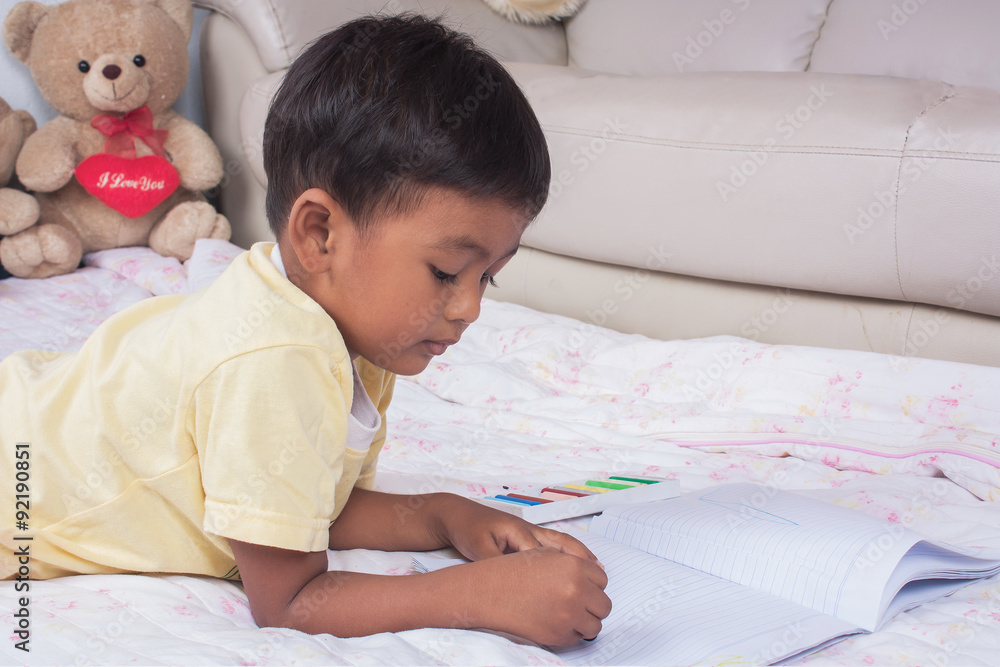 a little asian boy paint on white book in the room a little asian boy paint on white book in the room