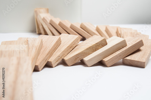 Foto Domino effect - row of white dominoes on white background