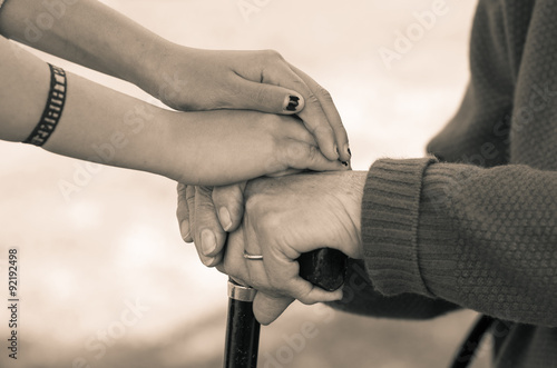 Closeup grandmother granddaughter holding hands, outdoors