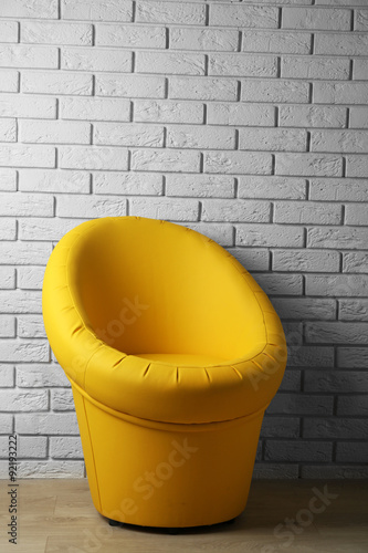 Modern chair on brick wall background © Africa Studio