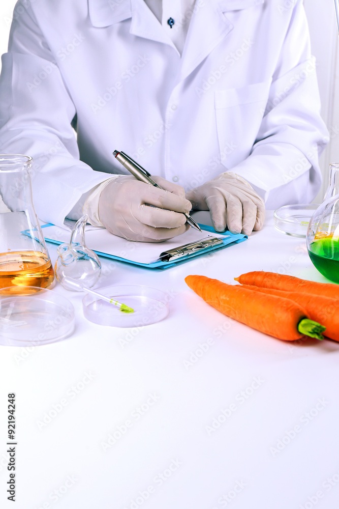 Scientist examines carrots in laboratory Scientist examines carrots in laboratory