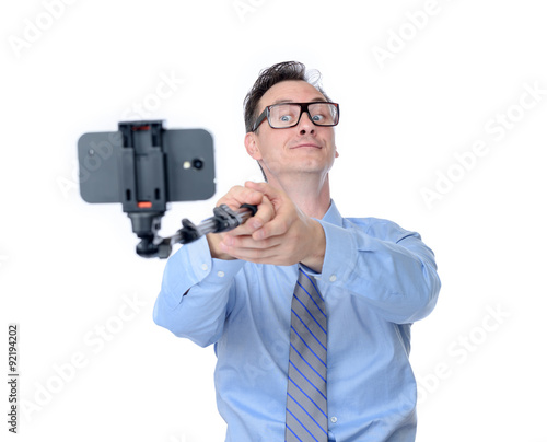 Man in glasses making selfie with a stick, isolated on white background 