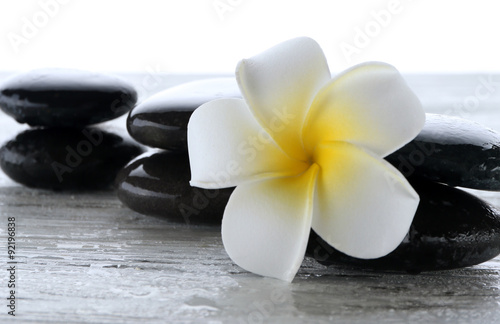 Wet spa stones with flower isolated on white