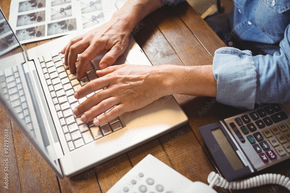 © Wavebreak Media - Cropped hand of creative businessman typing on laptop