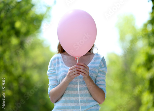 Girl holding balloon near face