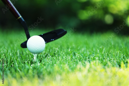 Golf balls and driver on green grass background