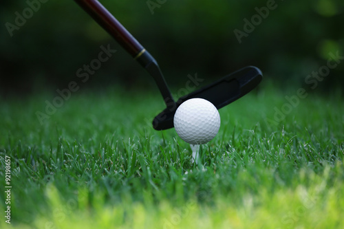 Golf balls and driver on green grass background