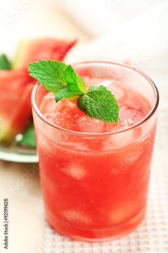 Cold watermelon drinks in glasses, on wooden table background