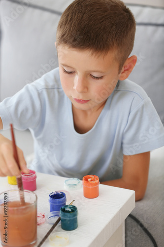 Cute little boy painting pi...