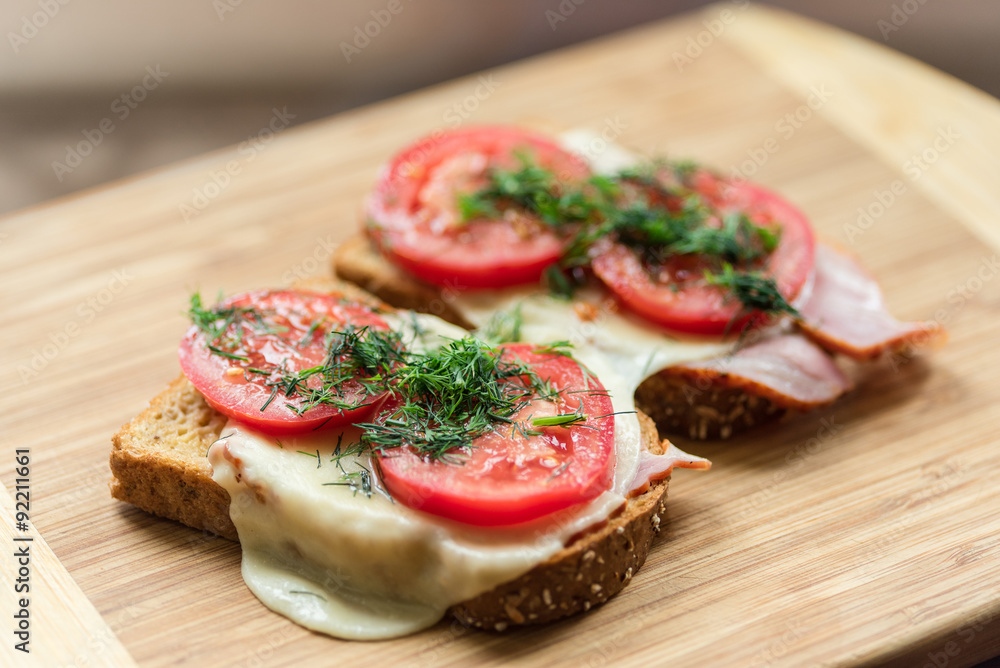 Morning breakfast sanwiches on a wooden cutting board with blurr