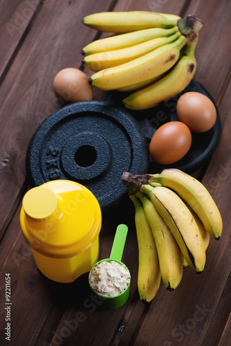 Protein scoop, plastic shaker, weight plates, eggs and bananas