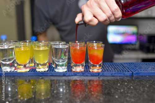 Barmen pouring colorful shots