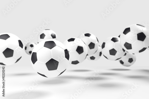 Levitation of the soccer balls  football  in front of the light-gray background. The light-gray background isolate the balls from the background. Focus to the nearest ball.