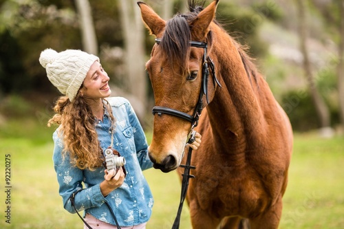 Young woman with her horse taking photo
