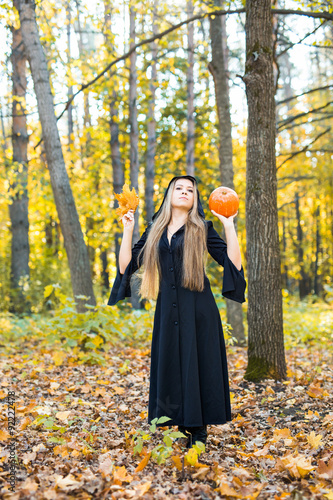 portrait of beautiful blond young woman holding pumpkin 