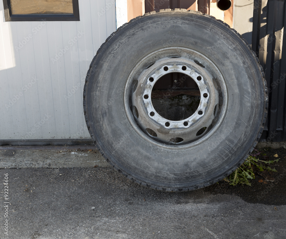 An isolated tire leaned against a wall An isolated tire leaned against a wall
