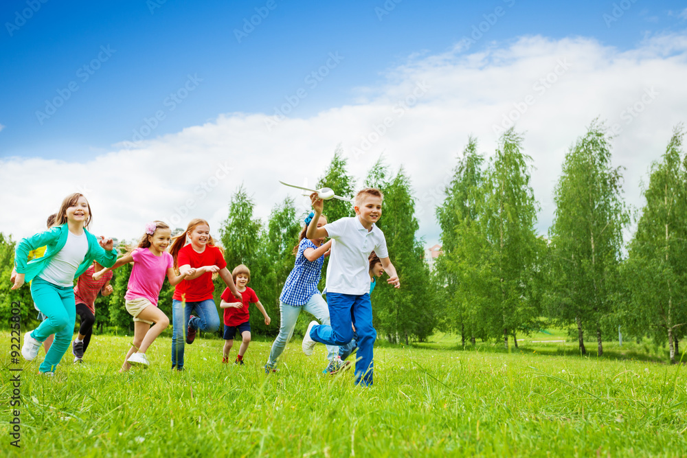 Obraz premium Boy with big airplane toy and children behind