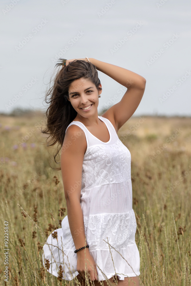 Close view of a beautiful woman on a white dress on the countryside.