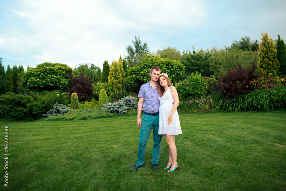 Fototapeta premium Happy and young pregnant couple in nature