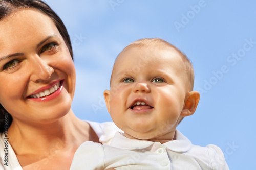 Close-up of cute baby and his mummy over sky