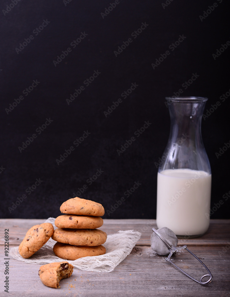 Stack of Chocolate chip cookie and bottle of milk with lace napk Stack of Chocolate chip cookie and bottle of milk with lace napk
