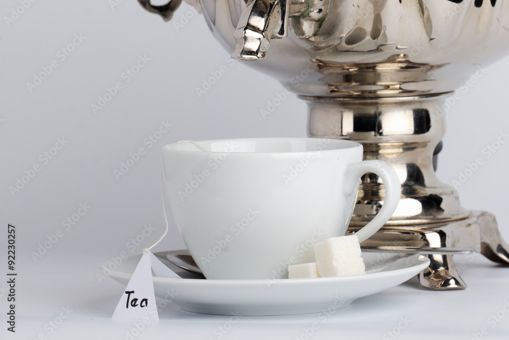The spout of the samovar over a cup of tea with tea bag. The spout of the samovar over a cup of tea with tea bag.