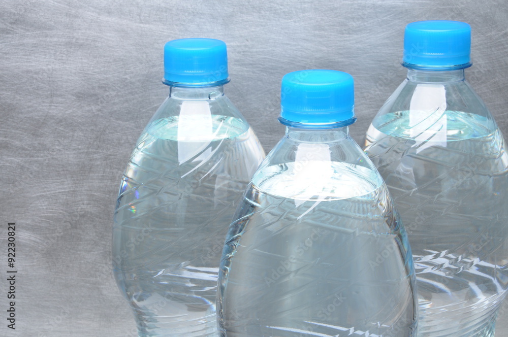 Plastic bottles of water on gray metal background