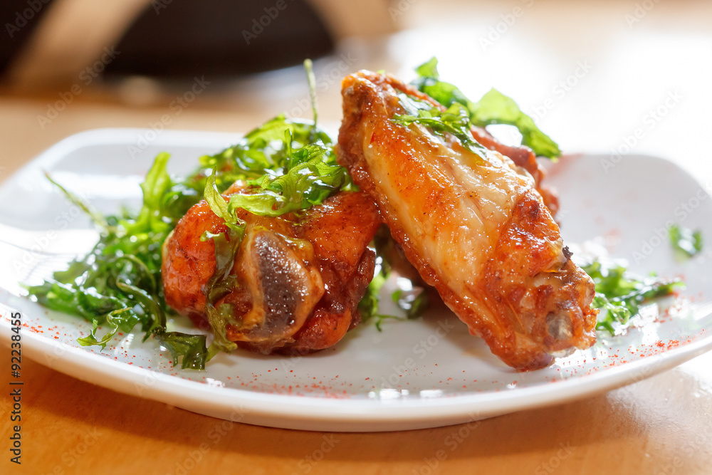 Fresh roasted chicken wings with arugula