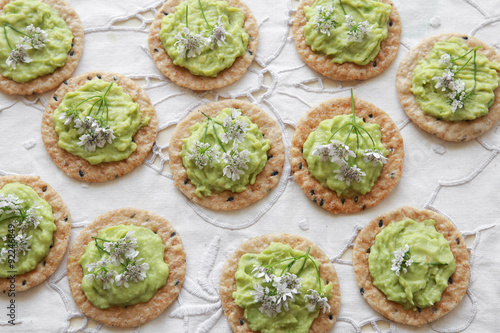 Green avocado crackers with coriander flowers