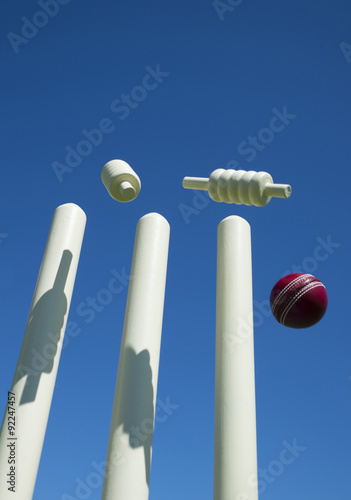 Bails fly in air after ball hits cricket stumps