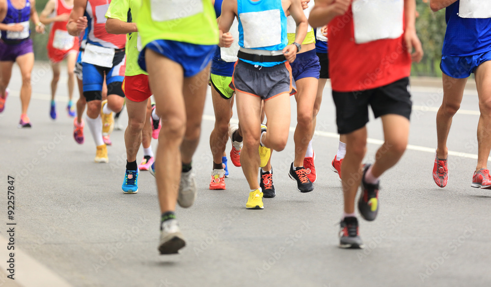 Many marathon runners running on city road