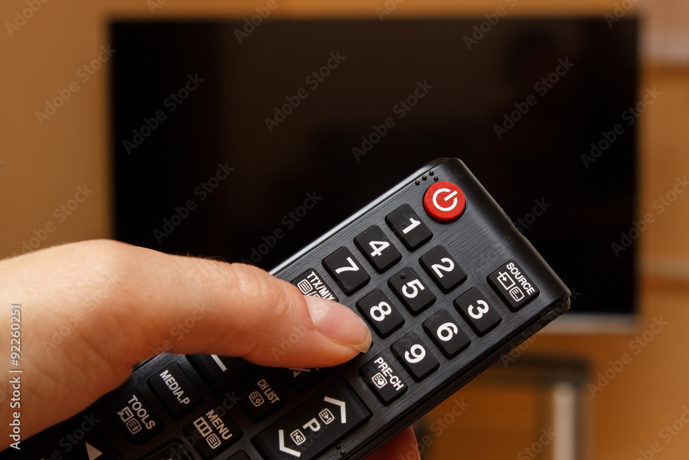 Hand holding remote control for television, choosing channel in TV Hand holding remote control for television, choosing channel in TV
