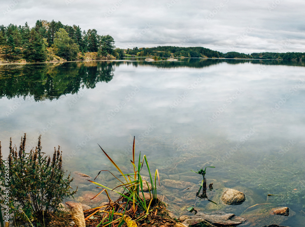 Fototapeta premium Beautiful autumn landscape, the lake with reflections and boats