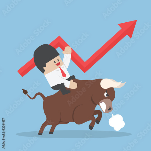 Businessman riding on bull