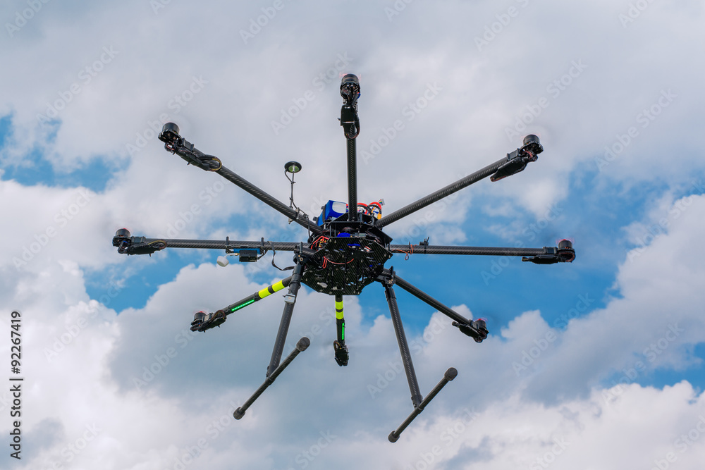 Multicopter in flight on sky and clouds background Multicopter in flight on sky and clouds background