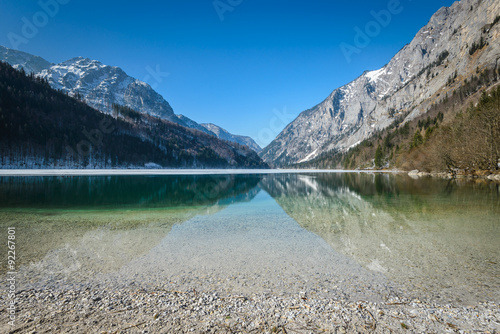 Landscape with root in lake water and mountains in background.Leopoldsteiner see,Styria,Austria. 