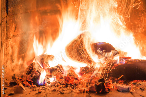 Firewood burning in fireplace fire heat red ashes interior