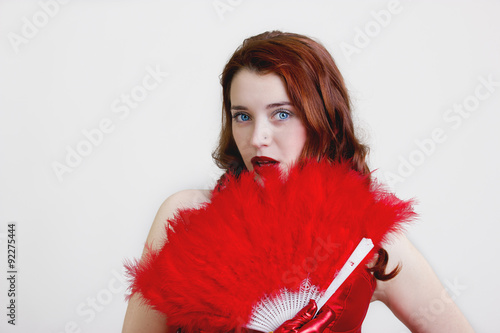 Beautiful redhead woman with red fan