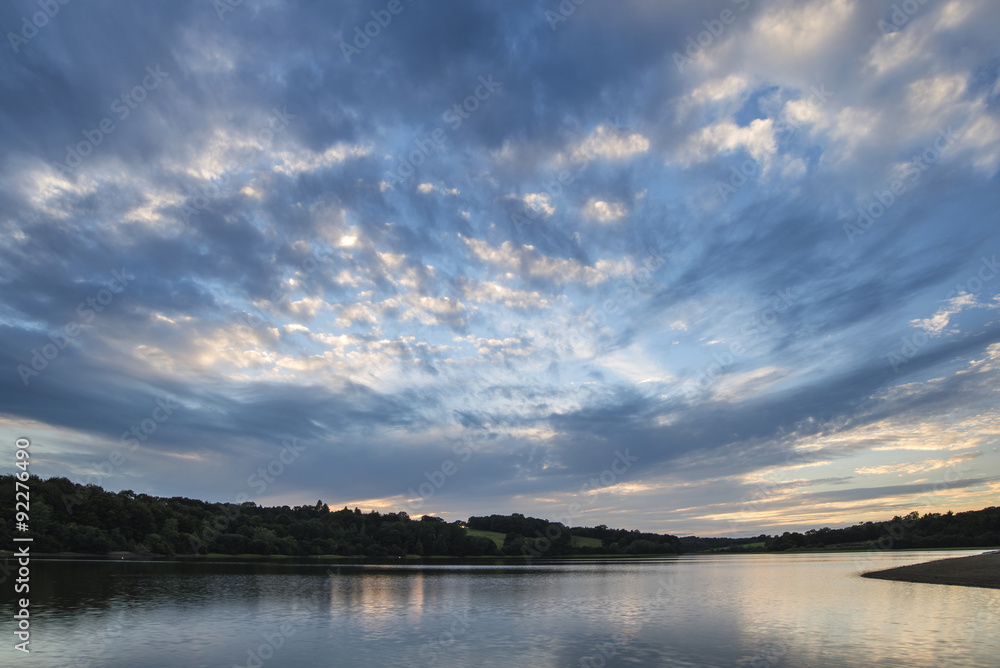 Dramatic stormy sunset over calm lake in Summer in English count