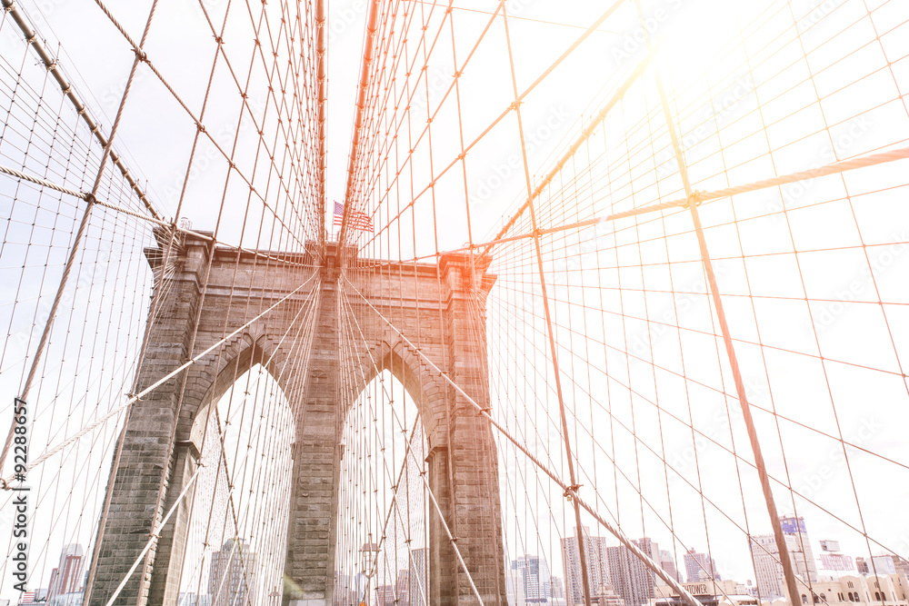 Fototapeta premium artistic view of the famous Brooklyin bridge in New York. Image taken on the upper part, with buildings skyline behind. concept about New york and traveling