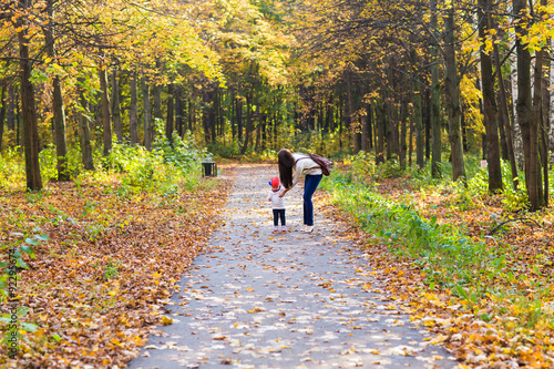 Young mother walking with her baby in an autumn park