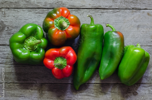 Green and red pepper on wooden background
