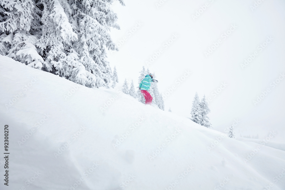 Girl in backcountry snowboarding
