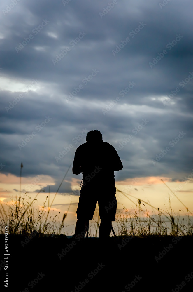 Silhouette of photographer taking pictures of sunset Silhouette of photographer taking pictures of sunset