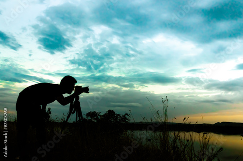 Silhouette of photographer taking pictures of sunset