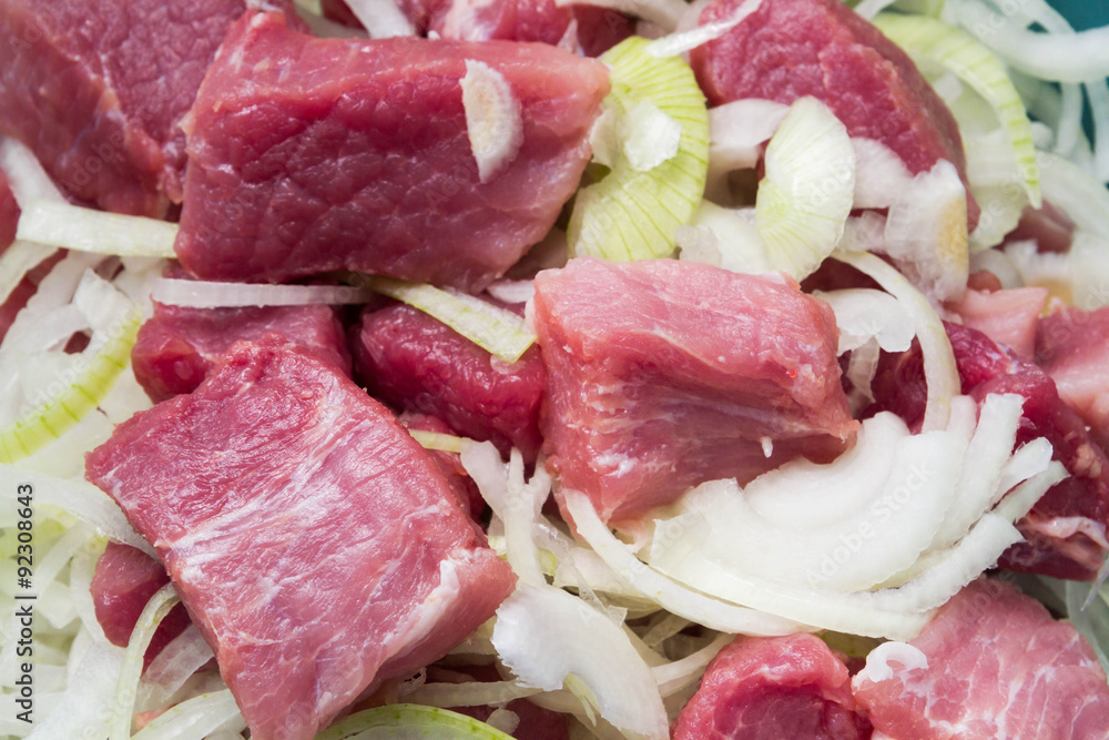Raw pork meat with onion preparing for barbecue